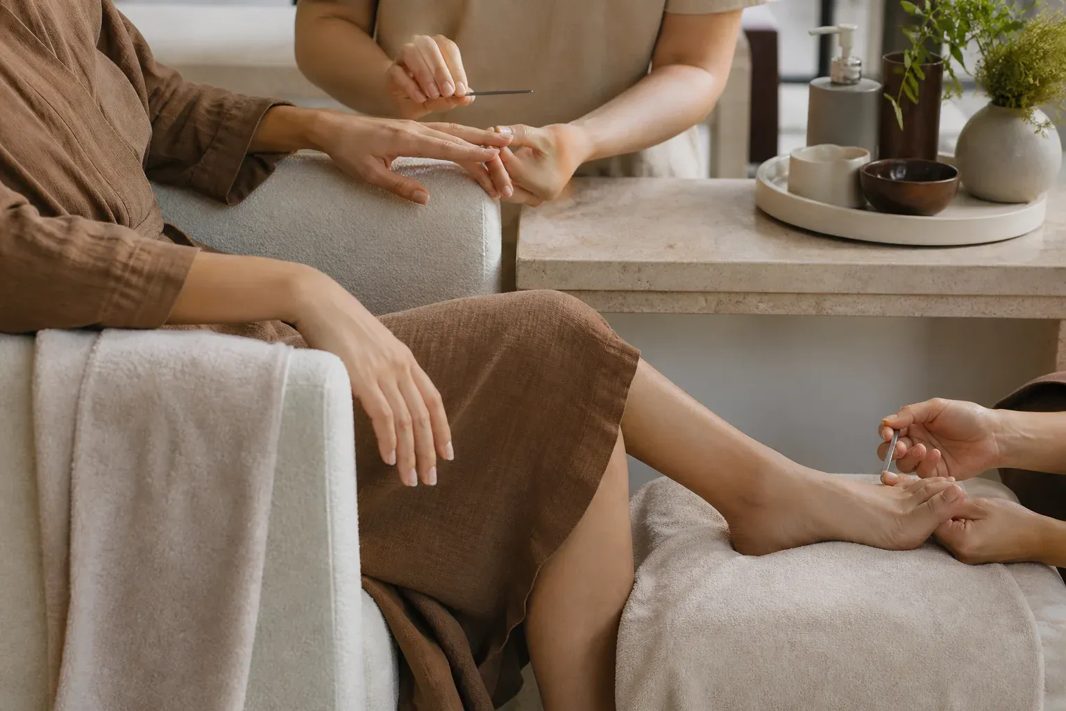 A client receiving hand and foot nail grooming during one salon appointment